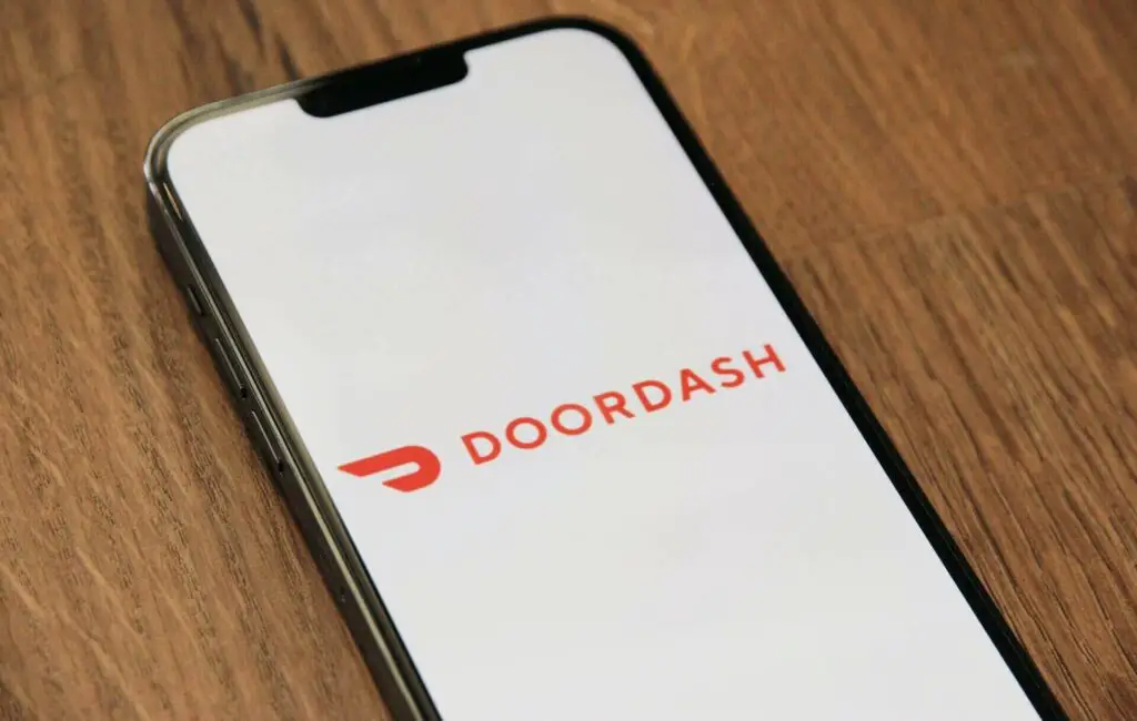 Phone with a logo of DoorDash on display