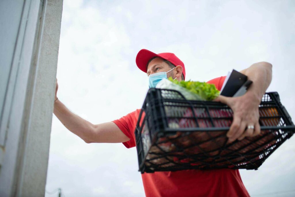 Man carrying a plastic basket with groceries