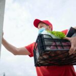 Man carrying a plastic basket with groceries