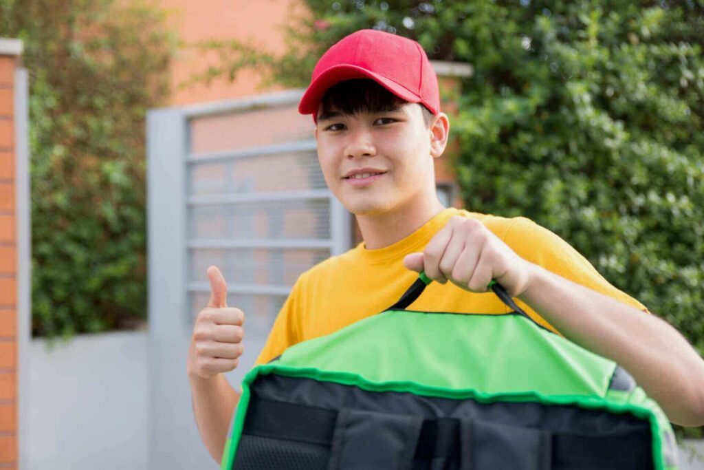 Man with a red cap and green bag smiling