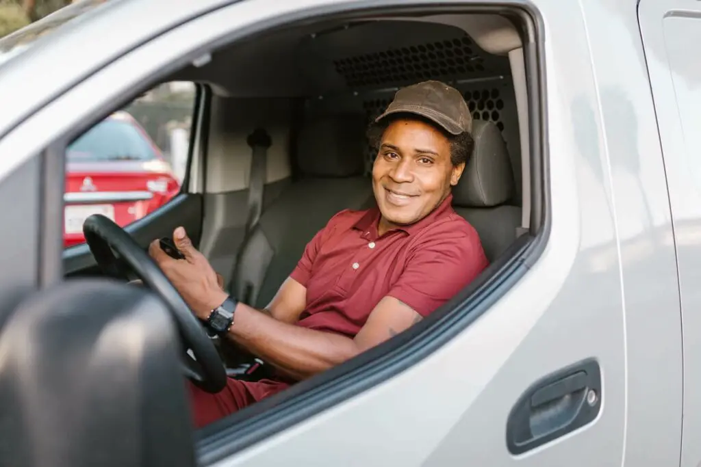 Delivery man sitting inside a car