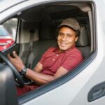 Delivery man sitting inside a car