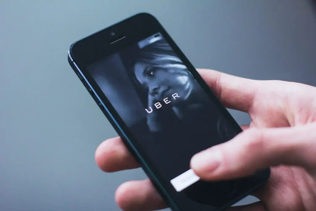 Person holding a smartphone with Uber logo on it